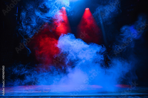 A stage with thick powder blue smoke illuminated by a bright red spotlight  providing a cool  dramatic visual.