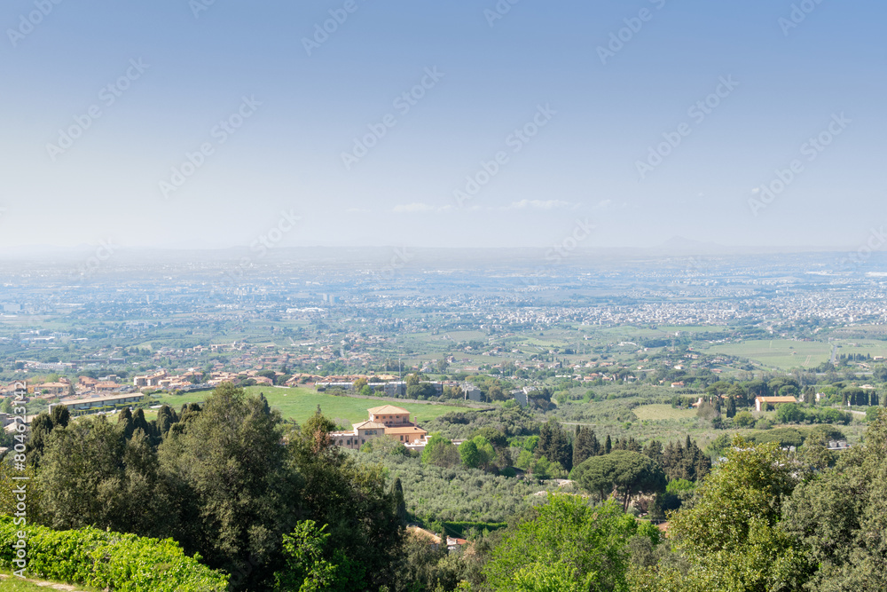 Picturesque panoramic view from the top of the valley in which the suburbs of Rome are located, sunny day, blue sky, distant horizon