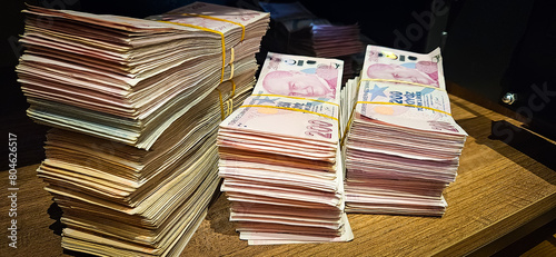 Tableau sur toile Bales of Turkish Lira banknotes in the bank in front of the cash register