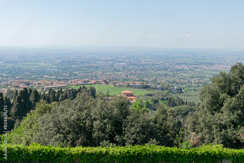 Majestic vista overlooking the valley where Rome's outskirts lie, under a sunny sky, with the distant horizon