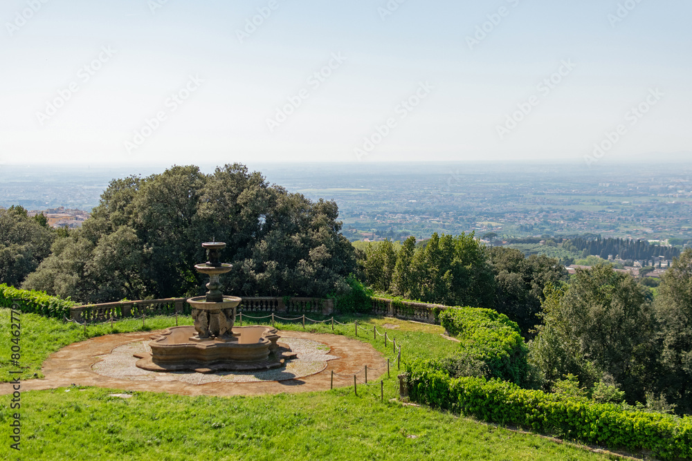Top view of the panoramic landscape of the valley, the country houses and gardens are visible to the horizon, in the foreground is a stone fountain - part of the garden of an ancient villa