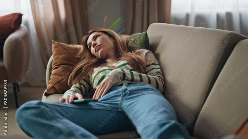 Sleepy woman resting couch holding mobile phone close up. Bored girl lying sofa Sleepy woman resting couch holding mobile phone close up. Bored girl lying sofa