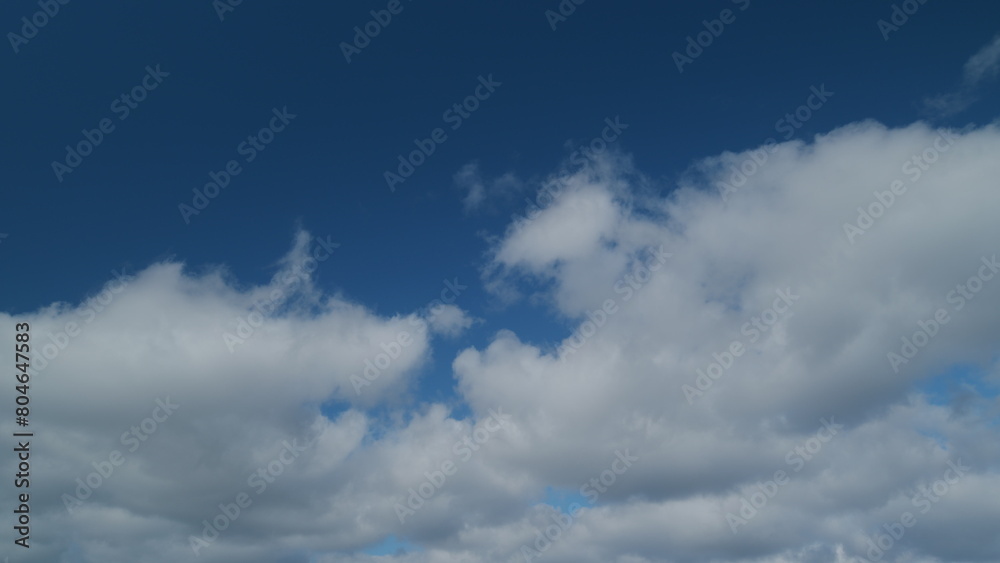 Changing stratocumulus cloudscape. Clouds in blue sky slowly move and change shape. Timelapse.