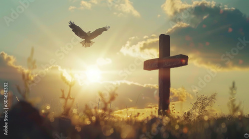 A cross with an eagle flying in the sky against an Easter sunrise background. Wide shot scene with a bokeh effect, sunlight, and copy space for text. 