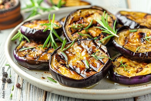 Grilled eggplants in plate on wooden table