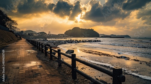 the sea  featuring an endless sidewalk leading to rocky shores  accompanied by a sky adorned with yellowish hues and fluffy white clouds drifting above the water s surface.