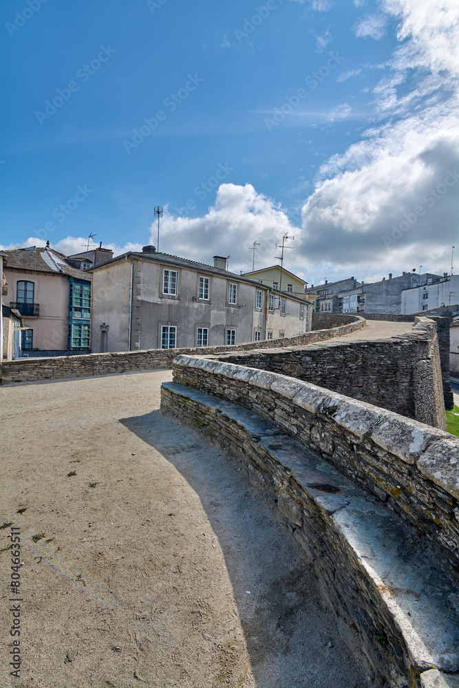 Exceptional capture of the Roman wall of Lugo, a historical fortification that stands majestically among nature and modern architecture, evoking centuries of history.