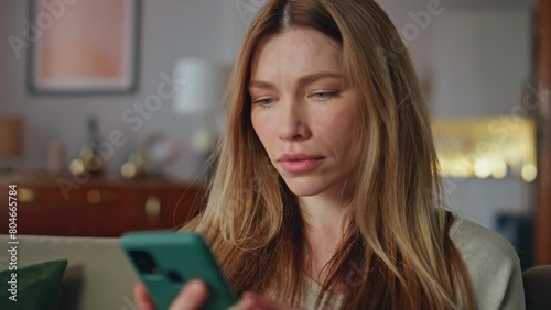 Shocked girl looking mobile phone in home closeup. Woman reading smartphone