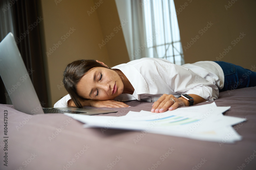 Young tired pretty caucasian businesswoman sleeping on bed in hotel room Young tired pretty caucasian businesswoman sleeping on bed in hotel room
