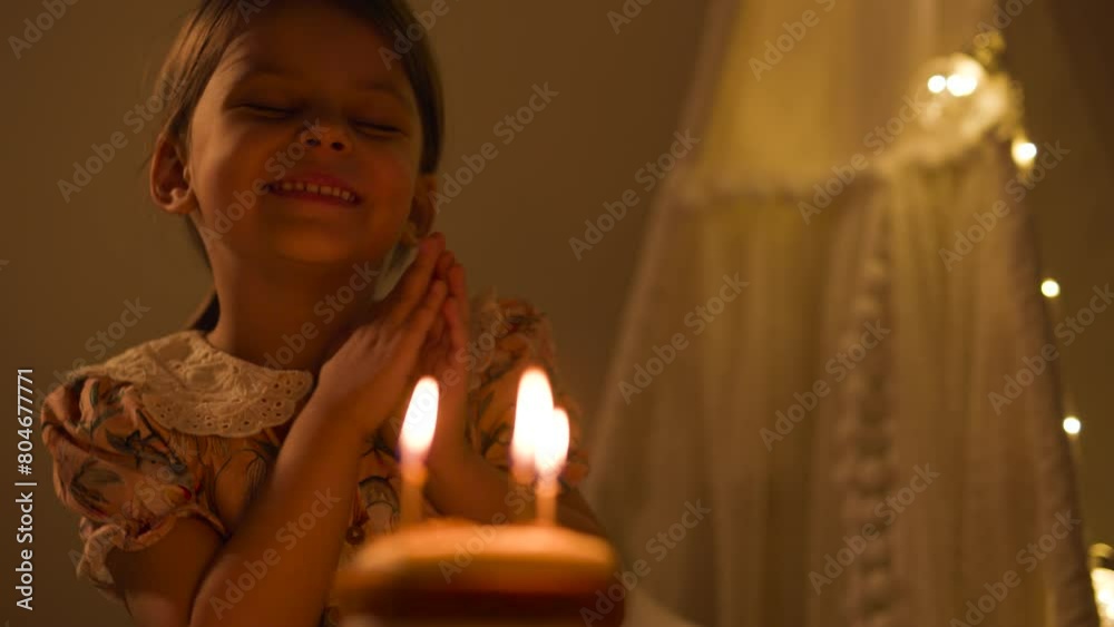 Happy child looks at a cake with candles. Girl celebrates birthday. Happy child looks at a cake with candles. Girl celebrates birthday.