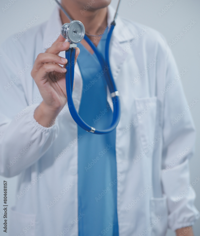 Senior doctor wearing white coat standing holding stethoscope in hands. Older male physician healthcare professional showing medical equipment ready to listen lungs or heart concept. Close up view Senior doctor wearing white coat standing holding stethoscope in hands. Older male physician healthcare professional showing medical equipment ready to listen lungs or heart concept. Close up view