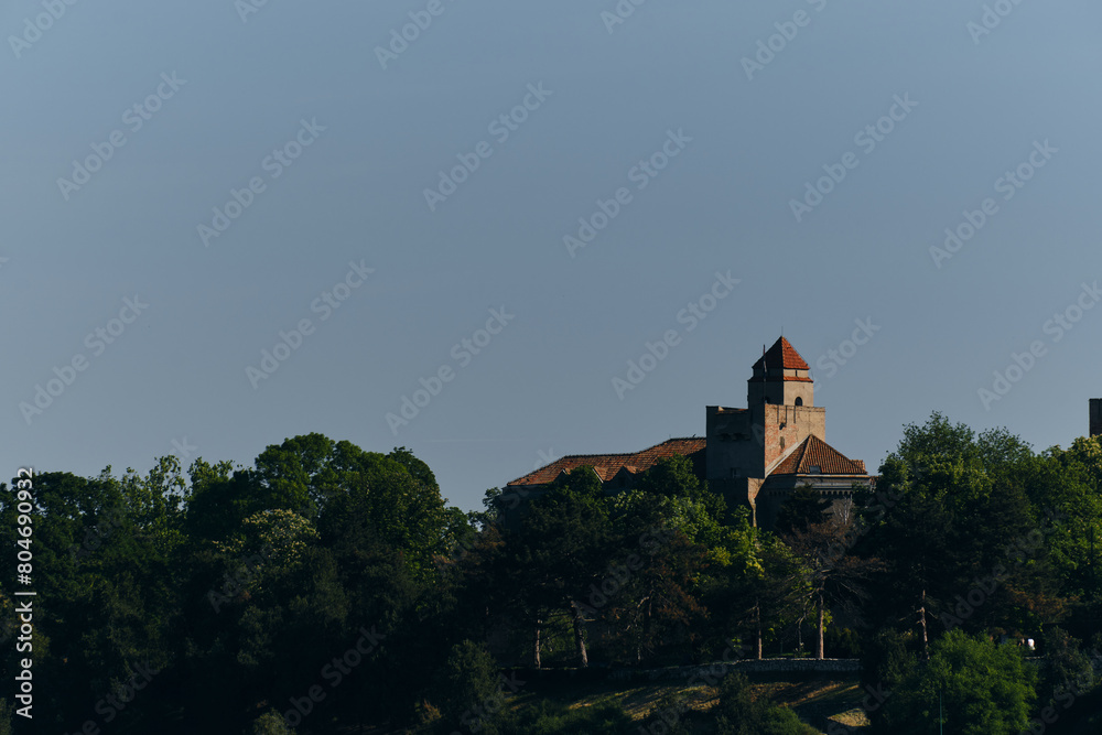 An old stone castle with a tiled roof on the territory of the Kalemegdan Fortress Park in the center of the old town. Green spring trees grow all around. Belgrade, Serbia. An old stone castle with a tiled roof on the territory of the Kalemegdan Fortress Park in the center of the old town. Green spring trees grow all around. Belgrade, Serbia.