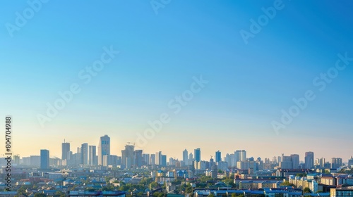 A wide panoramic view of a sprawling city skyline under a clear blue sky symbolizes growth and development