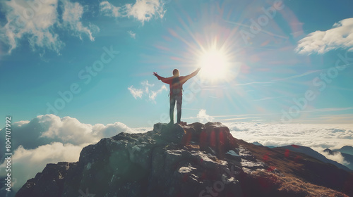 A man reaches the top of the mountain and rejoices at his success photo