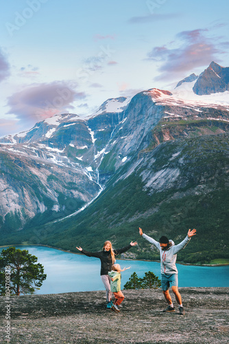 Family travel lifestyle - parents playing with child outdoor in Norway - mother, father and kid daughter on summer vacations hiking trip in Norway fjord and mountains sunset landscape