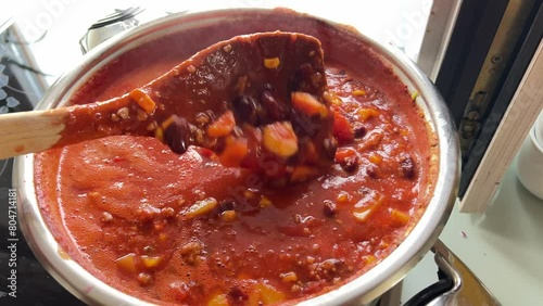 cooking delicious chili con carne in steel pot
