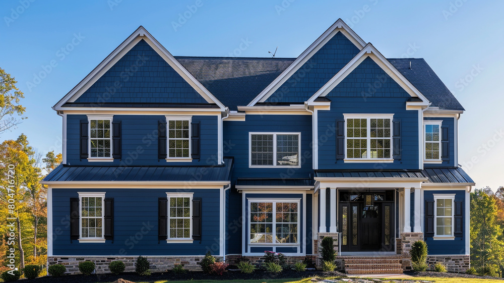 An elegant navy blue house with traditional windows and shutters stands out in the suburban landscape, its rich hue contrasting beautifully with the clear blue sky above.