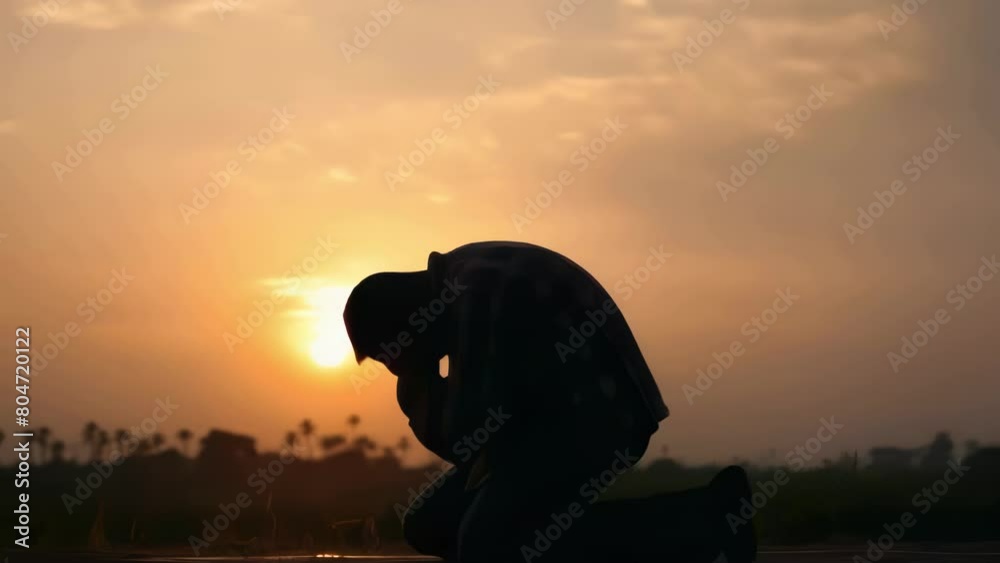 Man is kneeling in grass and praying