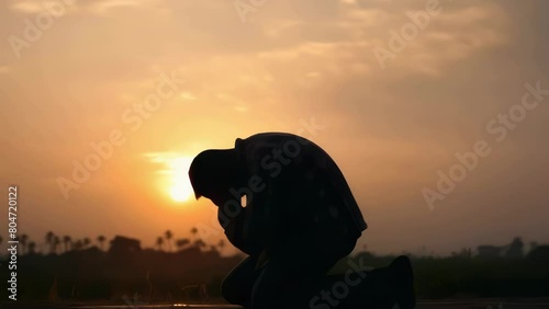 Man is kneeling in grass and praying