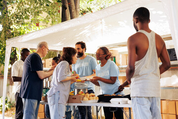 Humanitarian aid group assists in the distribution of contributions to people in need at a homeless and refugee shelter. Volunteers serve meals and provide help through a non-profit food bank.