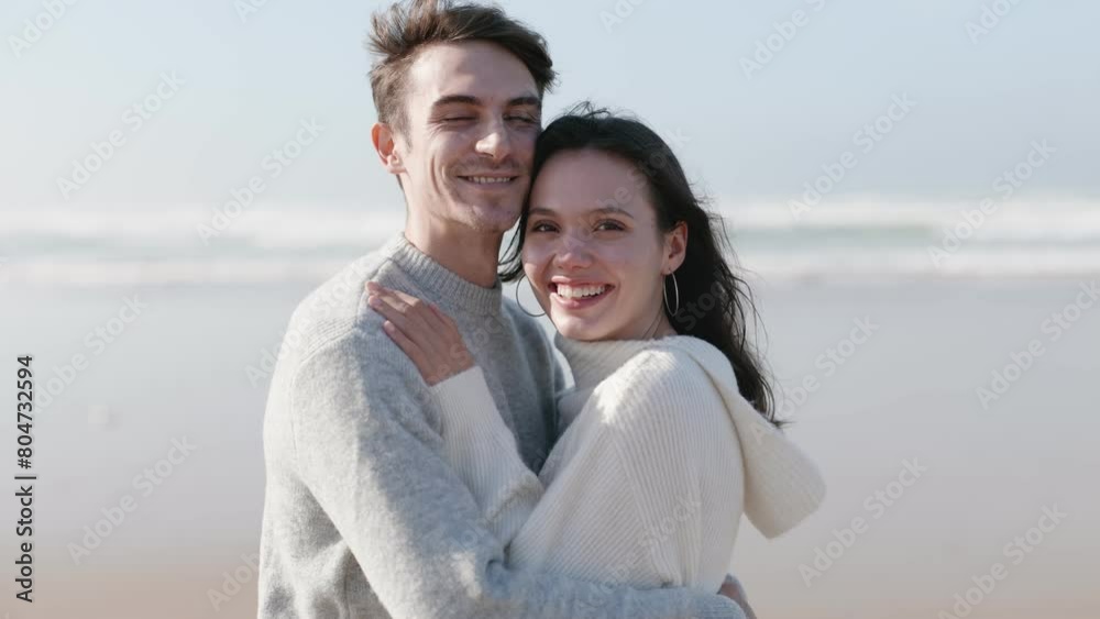 Joyful, in-love couple laughing and embracing on the beach, exuding energy and happiness while looking at the camera. Joyful, in-love couple laughing and embracing on the beach, exuding energy and happiness while looking at the camera.