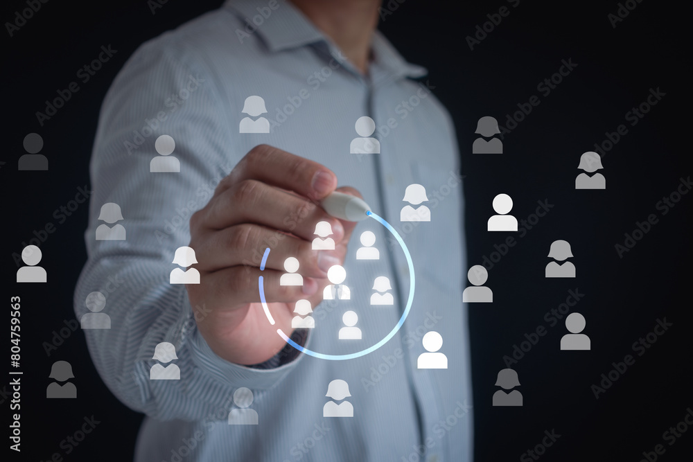 © MUNTHITA - Marketing target audience concept. Marketing segmentation, customer care, customer relationship management (CRM) and team building concepts. Businessman writing circle to mark to focus customer group.