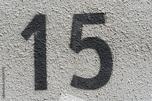 number 15 stenciled in black on a painted concrete surface