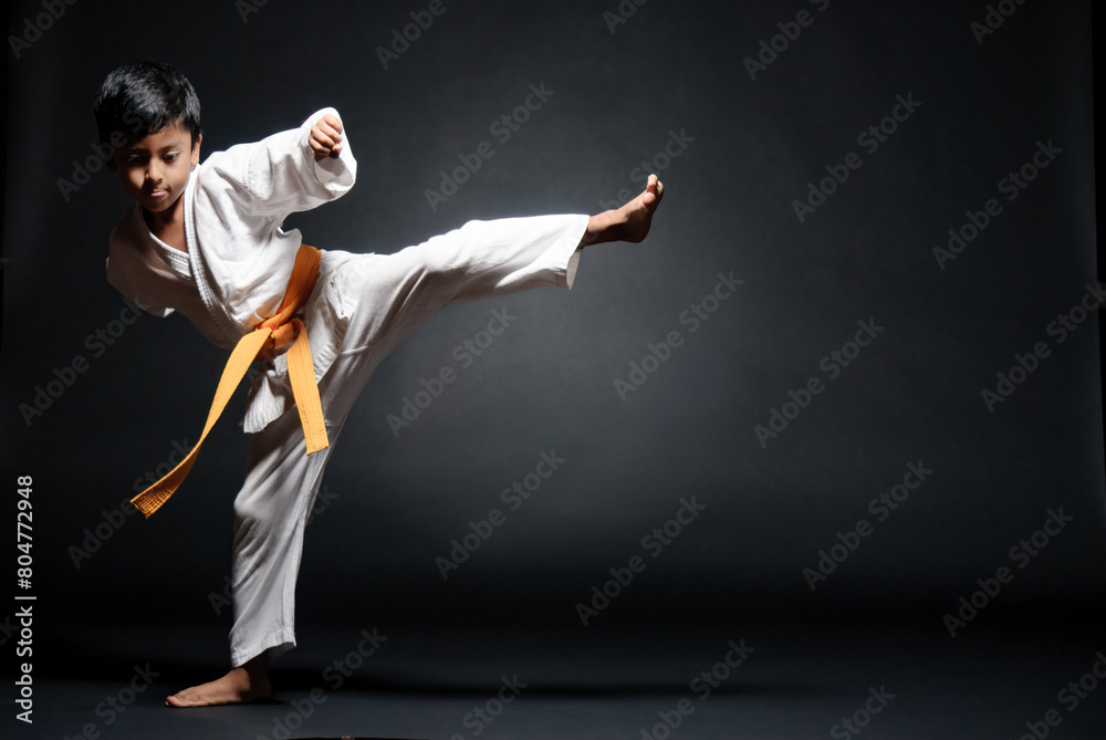 Latin boy doing Karate exercises. The leg raised to 90 degrees. Latin boy doing Karate exercises. The leg raised to 90 degrees.