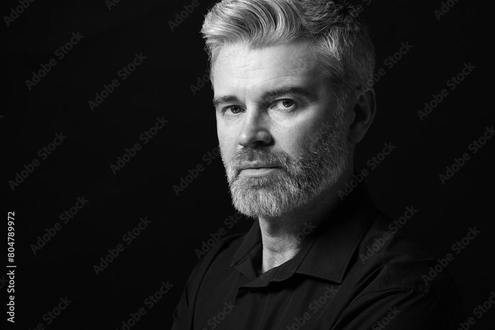 Fototapeta premium Portrait of handsome man on dark background, space for text. Black and white effect