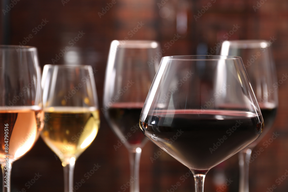 Obraz premium Tasty red wine in glass against blurred background, space for text