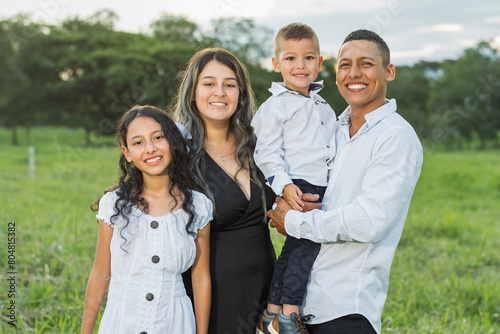 Colombian Latino family, smiling very happy, daughter, mother, father and son posing in the countryside.