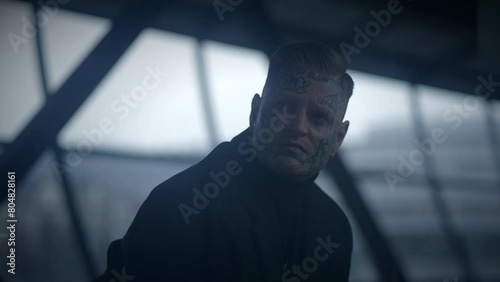 Intimidating Maverick Rebel Man with Head and Face Tattoos in Provoking Style photo