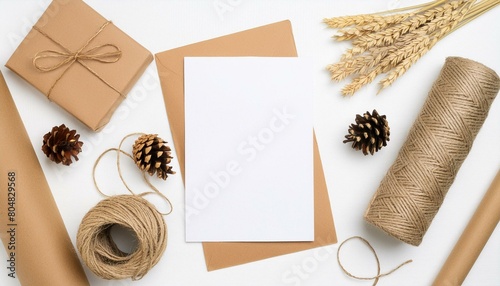 Craftsman workplace mockup with craft supplies and blank A4 paper list. Twine, cones, craft paper and envelope. Top view, flat lay with copy space