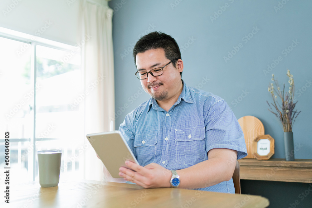 タブレット端末でイラストを描く大柄な日本人男性 タブレット端末でイラストを描く大柄な日本人男性