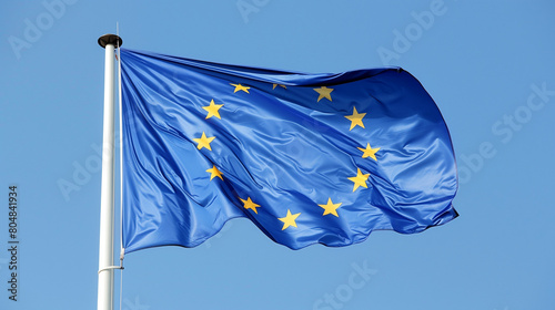An illustration of the European flag, featuring a single plain blue color with twelve gold stars arranged in a circle on a plain background resembling a blue sky. The flag's design is minimalist 