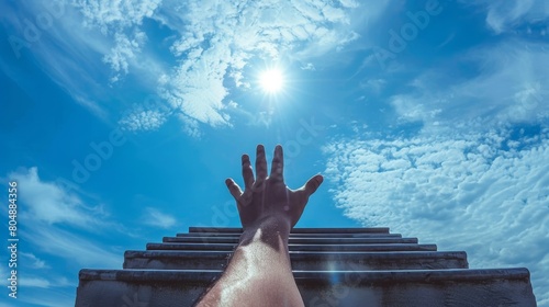 Staircase against a blue sky in the front view, with a man's hand aiming high, embodies the pursuit of career advancement