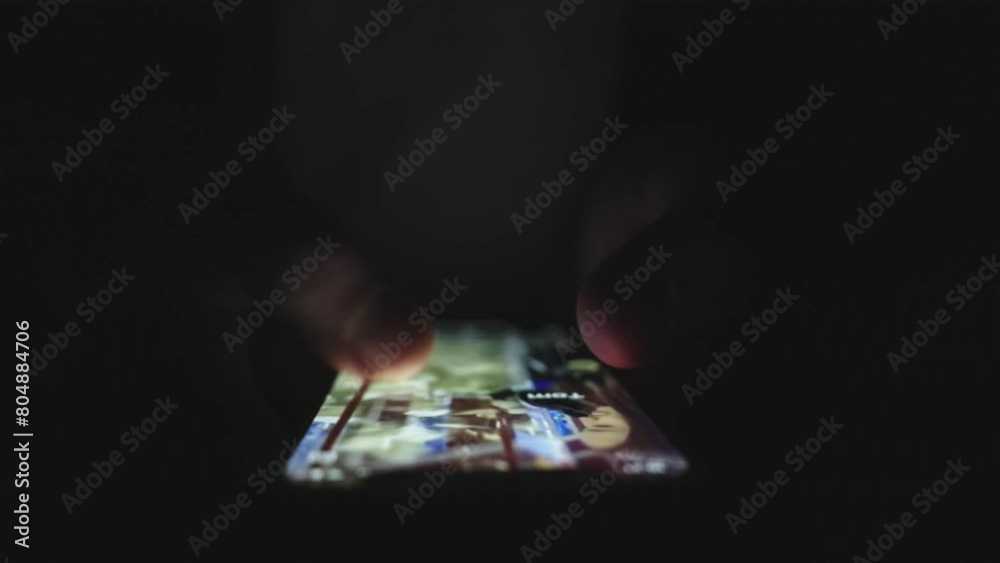 Male hands using mobile phone in darkness while finding information, swiping