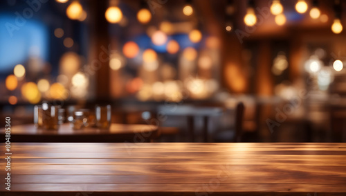 Image of empty wooden table in front of abstract blurred restaurant lights background