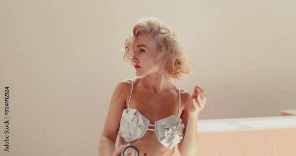 Beautiful woman applying hairspray posing for the camera. A woman models her hair. A beautiful model of hair styling with a spray. Women's cosmetics. Attractive woman is styling her hair using hairspr