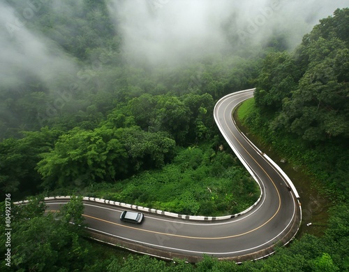 Aerial top view beautiful curve road on green forest in the rain season. © Beste stock