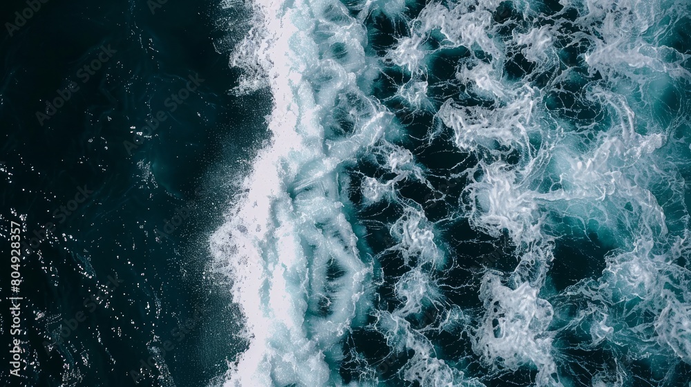 An aerial top view captures the mesmerizing white waves of the ocean, weaving a spectacular pattern on the sea's surface