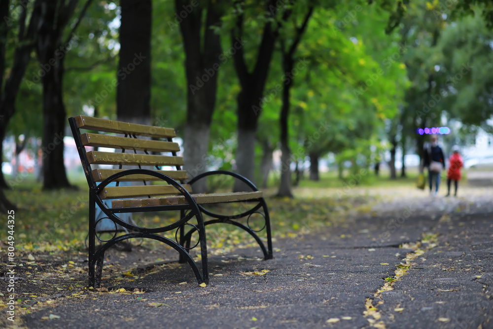 Autumnal park with bench. Falling leaves. Focus on bench Autumnal park with bench. Falling leaves. Focus on bench