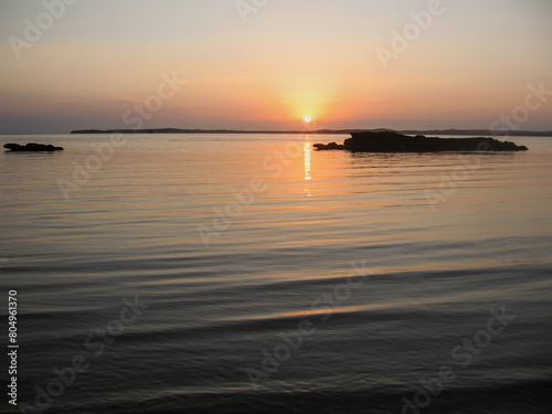 Sunset at KaNyaka Island in Southern Mozambique, with beachrock eroded into various shapes in the foreground and the Mozambique Mainland in the background