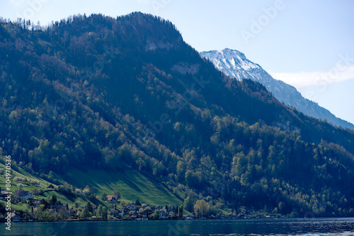 Rural landscape in the Swiss Alps seen from passenger ship running on Lake Lucerne between Kehrsiten and City of Lucerne on a sunny spring day. Photo taken April 11th  Lake Lucerne  Switzerland.