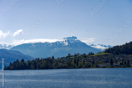 Rural landscape in the Swiss Alps seen from passenger ship running on Lake Lucerne between Kehrsiten and City of Lucerne on a sunny spring day. Photo taken April 11th, Lake Lucerne, Switzerland.