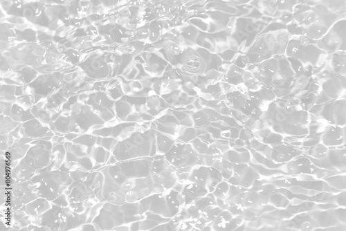 White water with ripples on the surface. Defocus blurred transparent white colored clear calm water surface texture with splashes and bubbles. Water waves with shining pattern texture background.