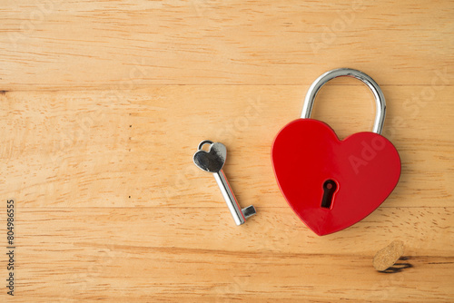 Love red heart shape padlock and key on wooden background. Find love, romantic, dating in online internet website, app dating community platform and Valentine day love symbol concept.