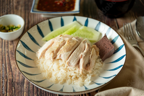 Traditional Hainanese chicken rice with salted soya beans sauce and soup on wooden background