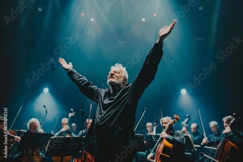 Conductor energetically directs orchestra on stage with arms raised