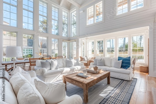 A bright and airy Nantucket home interior with a coastal-inspired living room filled with white furniture and large windows